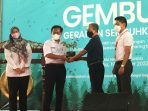 Penyerahan bibit tanaman oleh Gunarso (KIA) dan Fauzan (SCG) kepada kepala sekolah